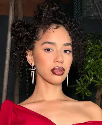 model wears natural makeup look with cranberry glossy lipstick