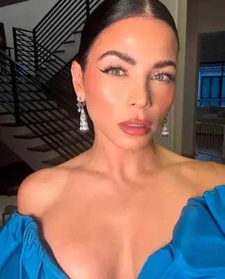 model wears winged eyeliner look with pink blush and glossy pink lips