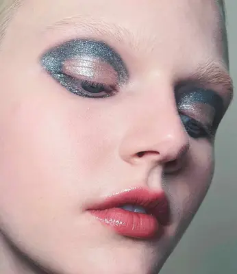 model is wearing silver glittery eyeshadow in a wing shape in the crease