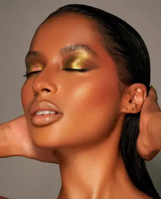 model is wearing visible golden gilded eyeshadow on the lids