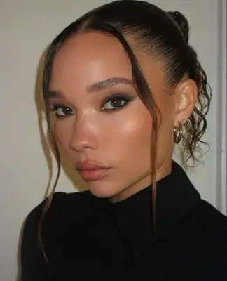 model is wearing subtle smoky eye with highlighted skin