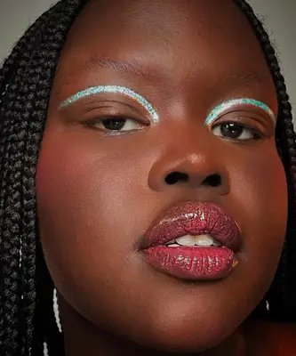 model is wearing holographic glitter eyeshadow and pink lipgloss