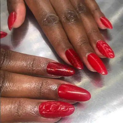 Red manicure with sparkly accent nails and subtle accent sweater nails