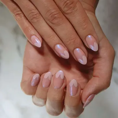Close-up of hands with manicured nails featuring delicate heart-shaped patterns