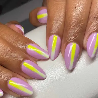 Manicured hands with nail art featuring diagonal stripes on nails