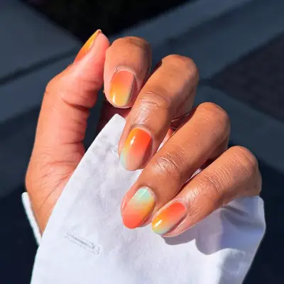 a sherbert manicure in shades of orange, yellow, and blue