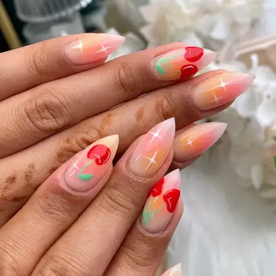 an airbrushed manicure topped with white stars and cherries