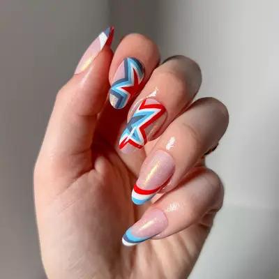 a manicure with red, white, and blue stars over a neutral chrome base
