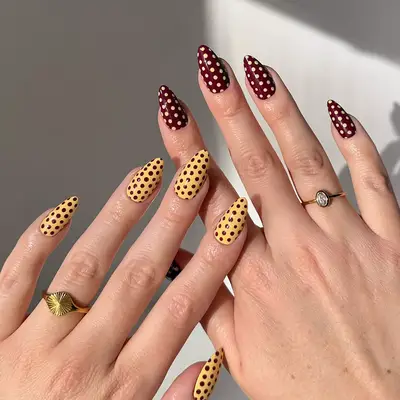 an inverted maroon and yellow polka dot manicure