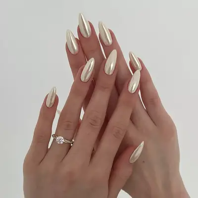 a vanilla chrome manicure on long almond nails