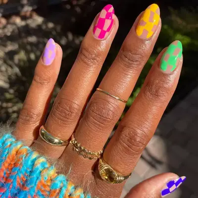 Hailey Bieber poses with a mismatched manicure featuring snakeskin and tie dye designs