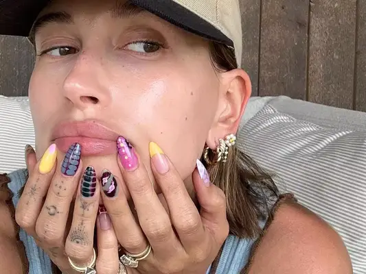 Hailey Bieber wears a mismatched manicure with snakeskin and tie dye designs