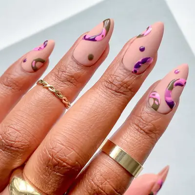 A close-up of a hand showcasing intricately designed nail art with abstract patterns