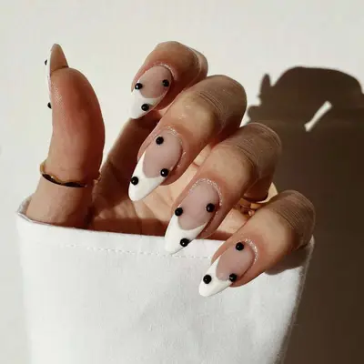 A white French manicure with studded accents 