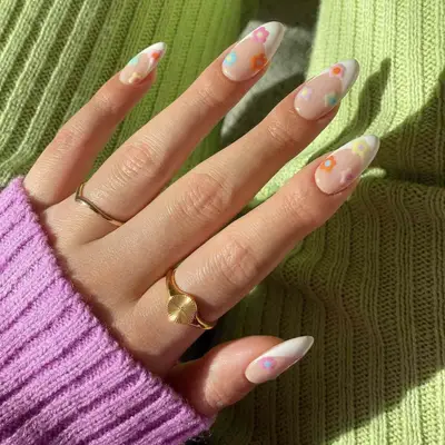A classic white French manicure with flower accents
