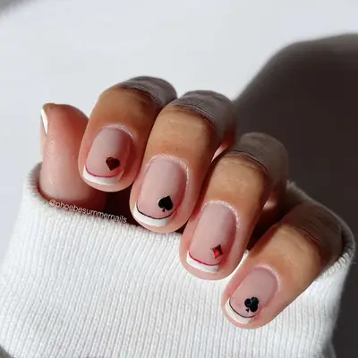 A white French manicure with deck of card accents