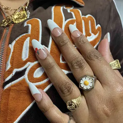 A white French manicure with a tiny cherry accent