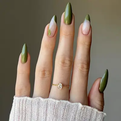 close up of nails painted in dark olive green shade with two nails having french tips in same green color