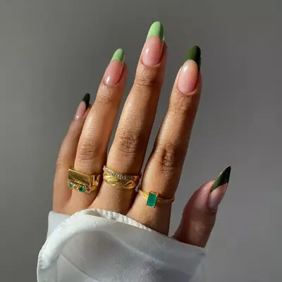 close up of nails painted in french tips in different shades of green for each nail