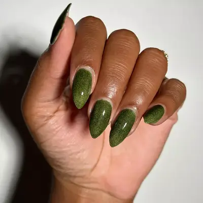 close up of nails painted in dark olive green shade with specks of black