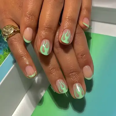 a manicure with mint green flames