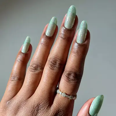 a sparkly mint green holographic manicure