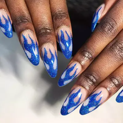 Long almond shaped nails with blue fire and glitter overlay