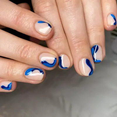 two-toned blue wavy design on neutral short nails