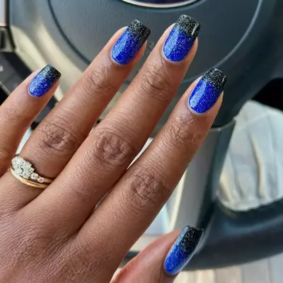 black french tips with blue base and glitter on top 