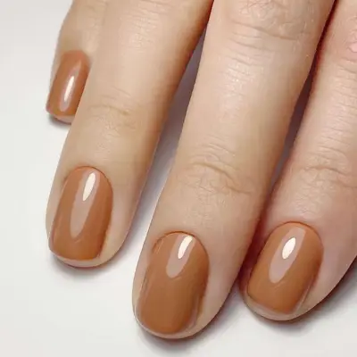 Close up of a glassy, latte-colored manicure