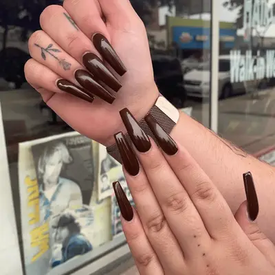 Close up of a mismatched negative-space and French brown manicure