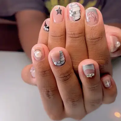 A mismatched manicure in shades of black, white, and silver