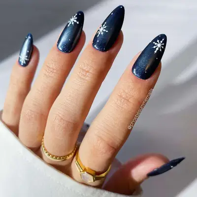 dark blue chrome nails with snowflake designs
