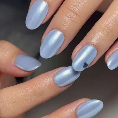 baby blue chrome nails with glittery heart accent