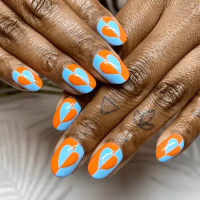 Aqua and orange nails with an optical illusion, mismatch color heart in the center.