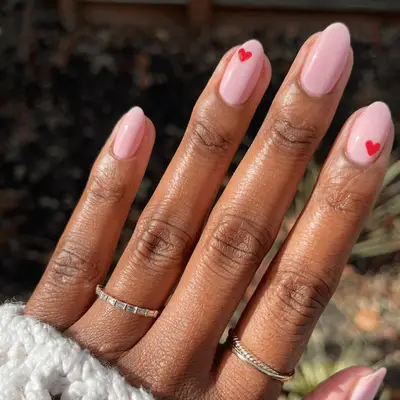 woman with light pink nails with red hearts