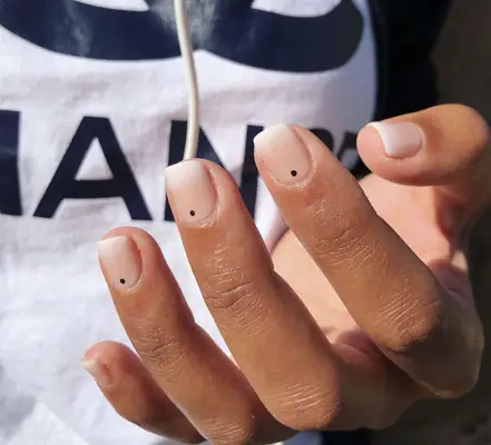 frosted ombre manicure with black dot designs 