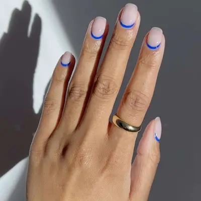 milky white manicure with blue cuticle designs 