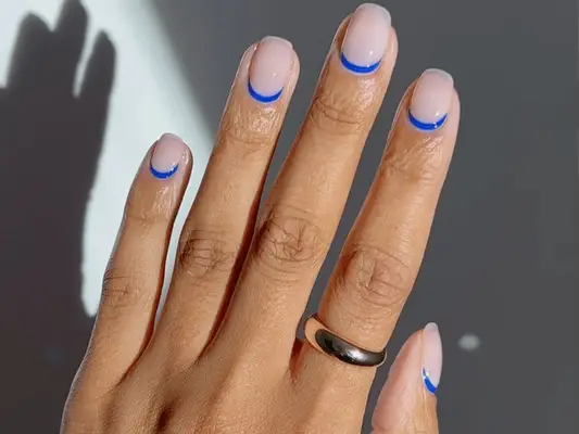 milky white manicure with blue cuticle design