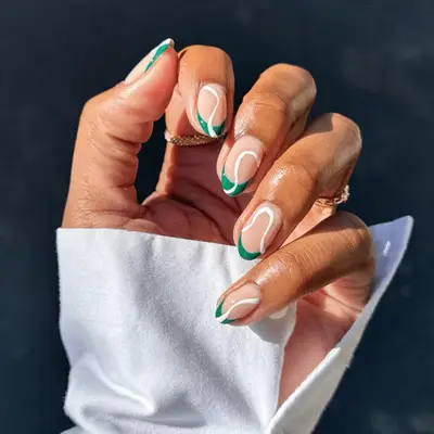 Green French tips with white swirl nail art detail