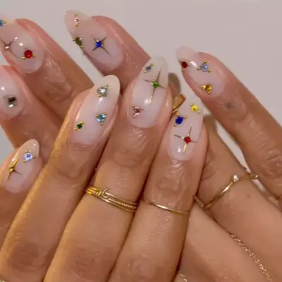 model with rainbow rhinestone nails