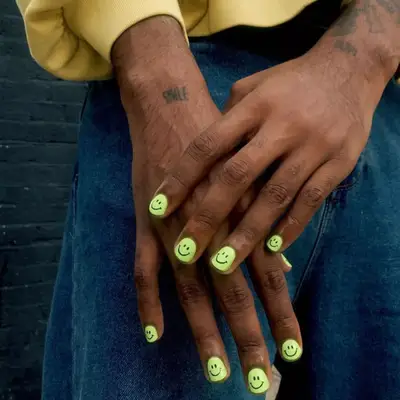 model with green nails with smile decal