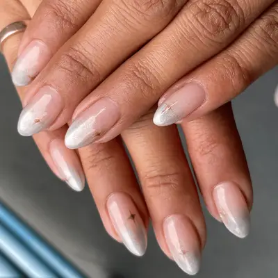 French manicure with silvery chrome gradient french tip and gold star accent