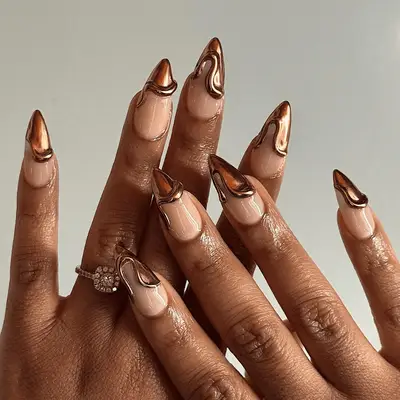 Pointed nails with 3D bronze chrome French tips.