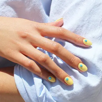 Bright yellow nails with blue 3-D dots at each base