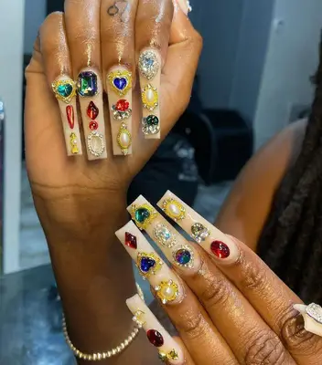 Long coffin nails with creamy polish and bejeweled nail stickers