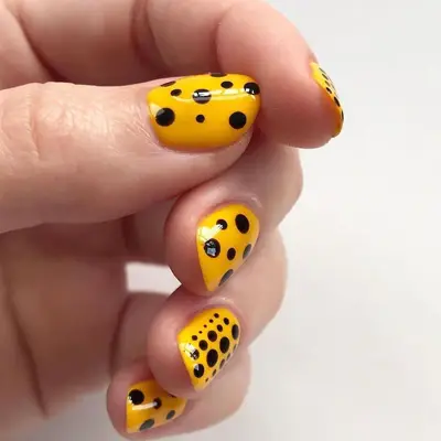 Yayoi Kusama-inspired black Dot design on yellow manicure