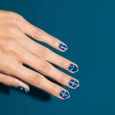 Smilie face nail design on blue polish base