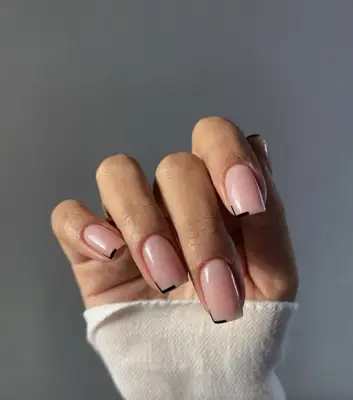 Square-shaped nails with light pink polish and black nail tip accent