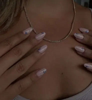 Nude nails with tiny evil eyes on each nail